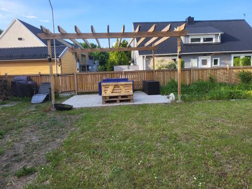 a backyard with a wooden pergola and a bench at Sahlin - Kattarp in Kattarp