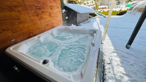 a jacuzzi tub filled with snow in a yard at CHATA POD HORAMA in Benecko