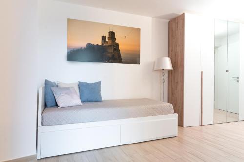 a white bedroom with a bed and a picture on the wall at Independent House a due passi dal Centro Storico in San Marino