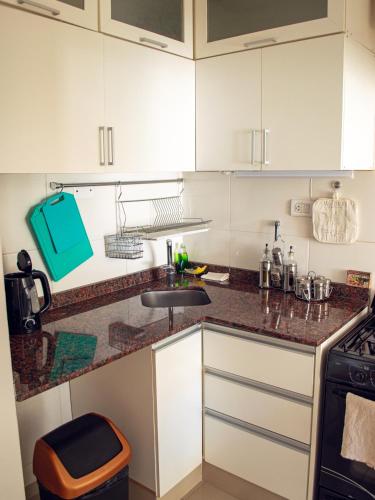 a kitchen with white cabinets and a sink at Dolce Casa Departamentos in Neuquén