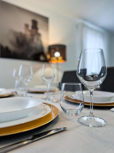 a table with three wine glasses and plates on it at Independent House a due passi dal Centro Storico in San Marino