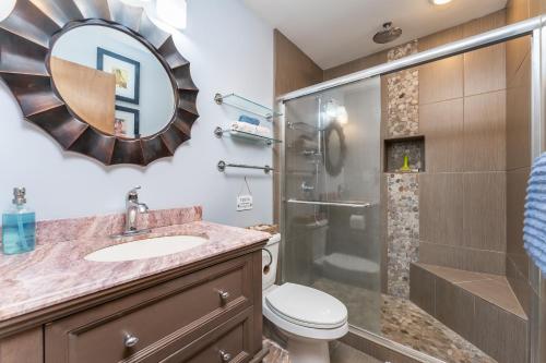 a bathroom with a shower and a toilet and a sink at Beautiful Kuilima East Estates Townhome - Golf Course & Ocean Views in Kahuku