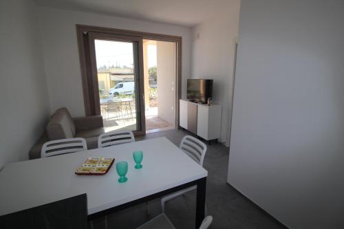a small living room with a white table and chairs at Athesis Lodges in Rosolina Mare