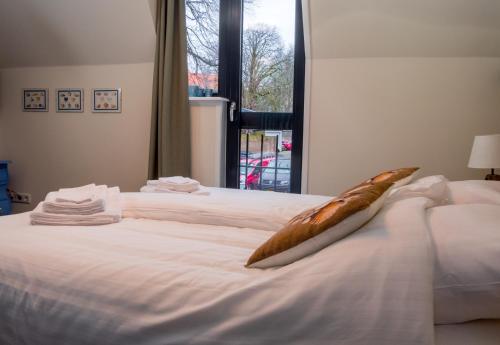 a large white bed with a fish pillow on it at Slapen bij Scherp in Middelburg