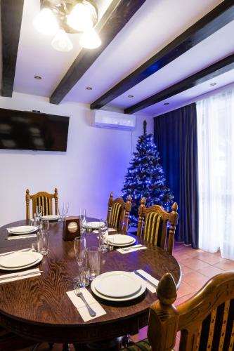 a dining room table with a christmas tree in the background at Готельний комплекс Парламент, Яблуниця in Yablunytsya