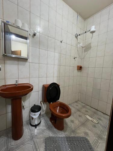 a bathroom with a toilet and a sink at Hotel Lima in Barra do Turvo