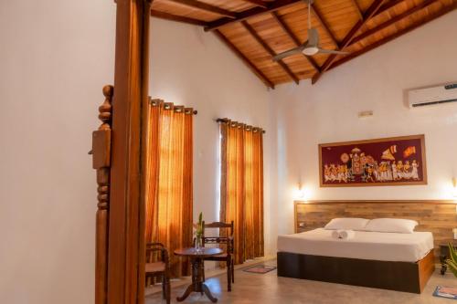 a bedroom with a bed and a table and a chair at Villa Summer Dream in Galle