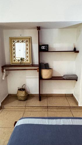 a bedroom with a mirror and shelves and a bed at Casa Eulogia y Fortunata con AC y Desayuno a pasos del mar in Zipolite