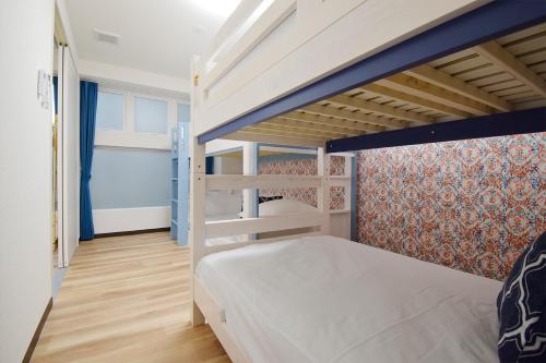 a small bedroom with a bunk bed and a wall at Hostel In Kyoto Gion - Vacation STAY 13469v in Gionmachi