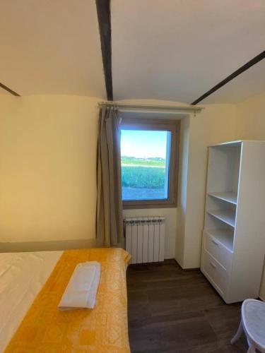 a small bedroom with a bed and a window at CASCINA BINELLO appartamenti A & B in Belvedere Langhe