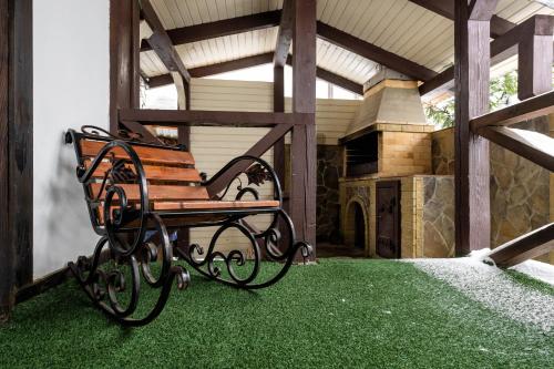 a bench sitting on a porch with green grass at Готельний комплекс Парламент, Яблуниця in Yablunytsya