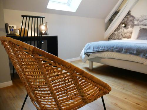 a bedroom with a bed and a wicker chair at KastellRen - Rennes - Grand parking privé in Rennes