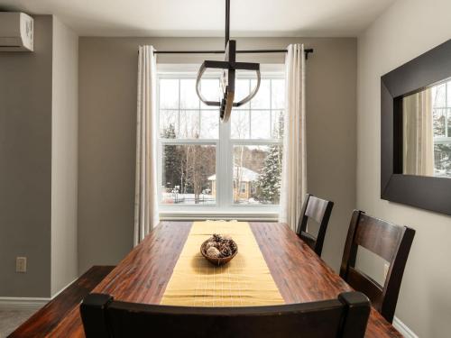 a dining room with a wooden table and a window at Ski In Out view on Mont-Blanc hills - Le Loup in Mont-Blanc