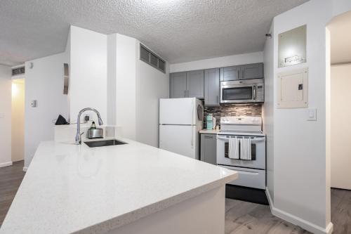 a kitchen with white appliances and a white counter top at Downtown Honolulu Skyview - 1Bed&Den- Free Parking in Honolulu