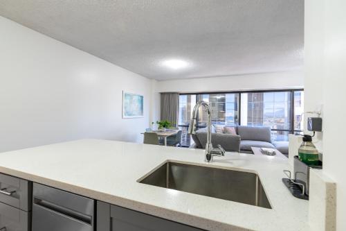 a kitchen with a sink and a living room at Downtown Honolulu Skyview - 1Bed&Den- Free Parking in Honolulu
