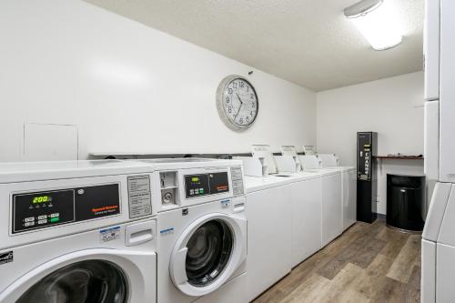 a laundry room with washing machines and a clock on the wall at Spacious Downtown Executive Retreat - Free Parking in Honolulu