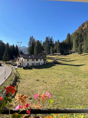 a house in a field next to a road at Locanda al Toal in Moena