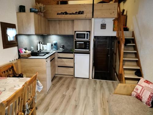 une petite cuisine avec un escalier dans une petite maison dans l'établissement Résidence Les Cassettes - Appartement Mezzanine 4 personnes 3 exposé Sud MAE-5994, à Valloire