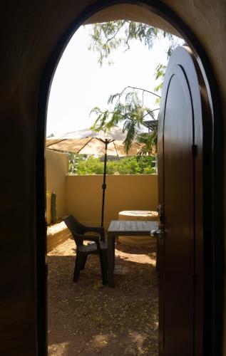 an archway with a table and an umbrella and a bench at CACTACEO - alojamiento desértico in Chapala