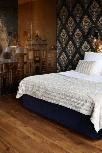 a bedroom with a bed and a wall with a picture at Stadshotel Geertruidenberg in Geertruidenberg