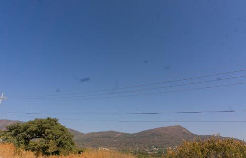 a view of mountains with a blue sky and power lines at CACTACEO - alojamiento desértico in Chapala