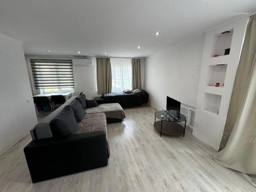 Una sala de estar con un sofá y un televisor. en Aronsona, en Krāslava