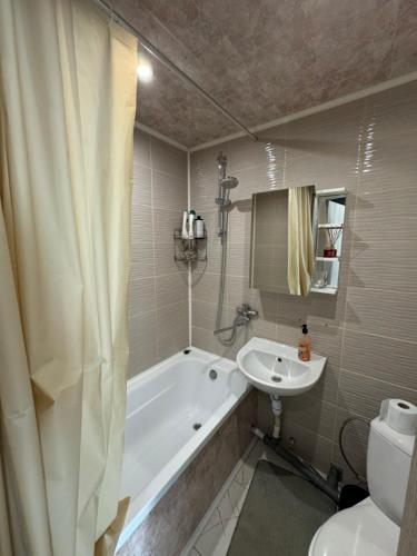 Un baño con bañera, lavabo e inodoro. en Aronsona, en Krāslava