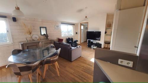 un salon avec un canapé et une table dans une pièce dans l'établissement Les pléiades, à Lamballe Armor