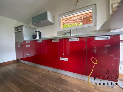 a kitchen with red cabinets and a window at Les pléiades in Lamballe Armor