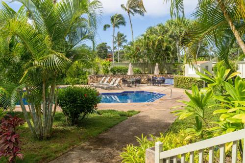 a resort with a pool and palm trees at Rare 2 Bedroom & Loft Townhouse on the North Shore in Kahuku