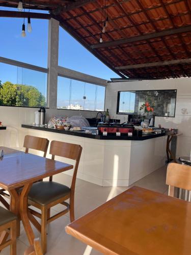 a kitchen with a table and chairs and some windows at POUSADA PEDRA DE JACÓ in Lauro de Freitas