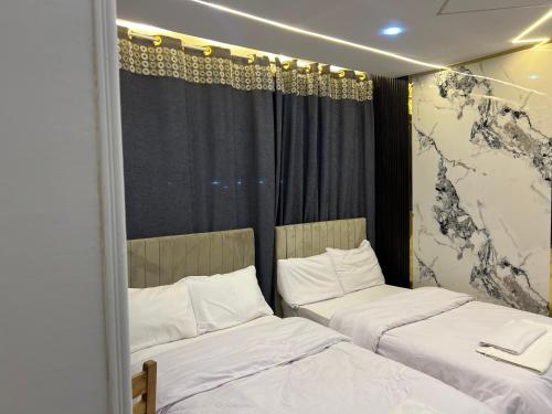two beds with white sheets in a room at Miracle Pyramids View Hotel in Giza