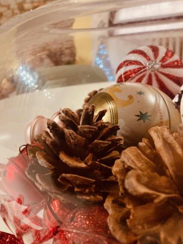 a pine cone and a christmas ornament on a plate at Residenza Borgo 9 in Collecchio