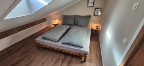 a small bed in a room with two lamps at Ferienwohnung SEElig in Fischbachau