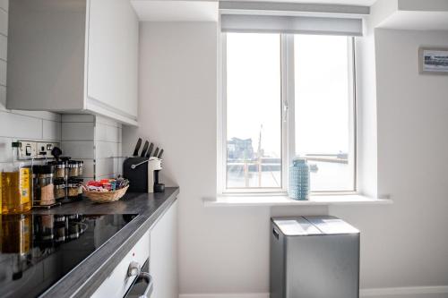 a kitchen with white cabinets and a window at Radharc na mBáid in Galway