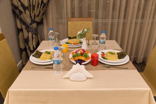a table with plates of food and bottles of water at Carmine Otel in Kırıkkale