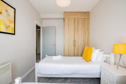 a bedroom with a white bed with yellow pillows at Radharc na mBáid in Galway
