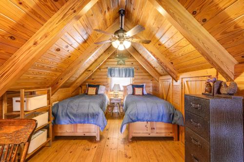 two beds in a log cabin bedroom with a ceiling at Steps to Lake Okeechobee Cabin with Pool Access! in Okeechobee