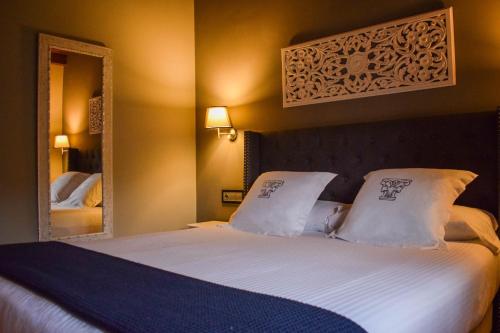 a bedroom with a bed with white sheets and a mirror at Casona De La Pinta in Ríocorvo