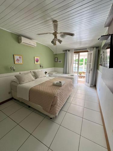 Un dormitorio con una cama y un ventilador de techo. en Pousada Paty´s Garden, en Florianópolis