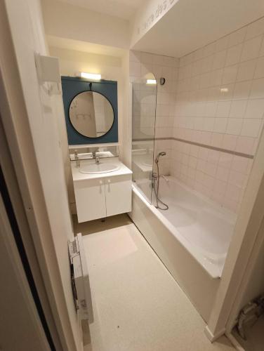 une salle de bain avec un lavabo, une baignoire et un miroir dans l'établissement Bel appartement 50m de la plage, à Wissant