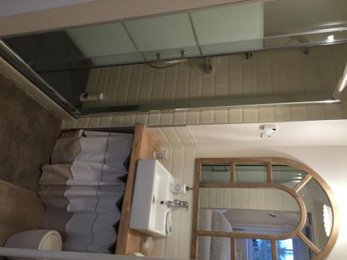 une petite chambre avec un lit et un miroir dans l'établissement Chambres d'hôtes Le Mont d'Anon, à Goviller