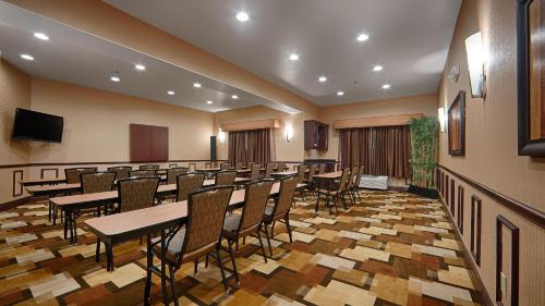 a conference room with tables and chairs and a television at Best Western Plus KC Speedway Inn & Suites in Kansas City