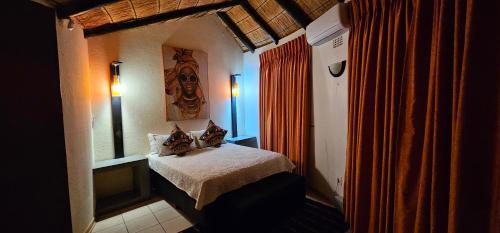 a small bedroom with a bed in a room at The Big Rondawel in Marloth Park