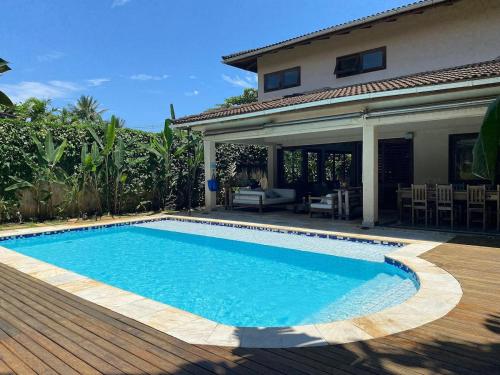a swimming pool in front of a house at Casa Conforto Barra do Una in São Sebastião