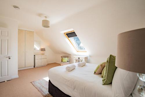 a bedroom with a large white bed with a window at City Townhouse with parking in Galway