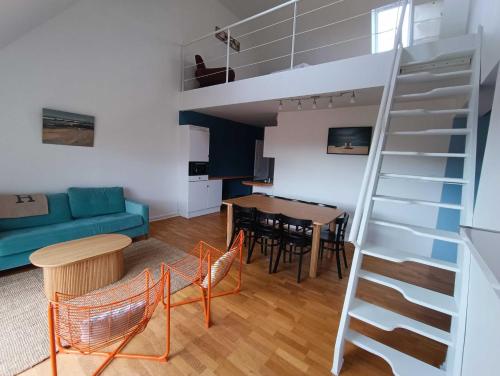 un soggiorno con scala e una sala da pranzo di Bel appartement 50m de la plage a Wissant