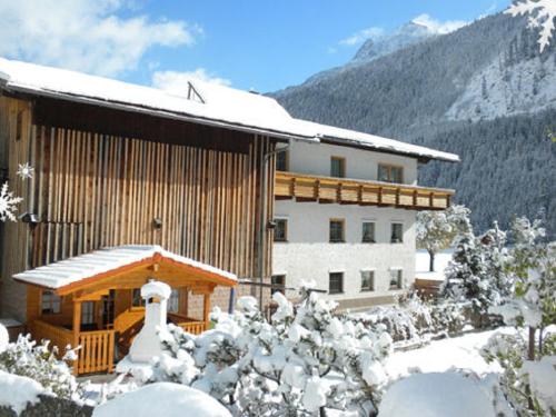 a building in the snow with snow covered trees at Ferienhaus Wechner in Häselgehr