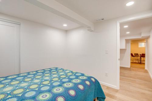 a white room with a bed with a blue blanket at Spacious Home with Fenced Yard 6 Mi to Dtwn Denver! in Englewood