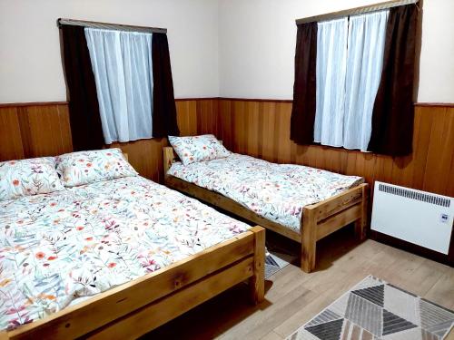 a room with two beds and two windows at Kablar Lazino Brdo in Čačak